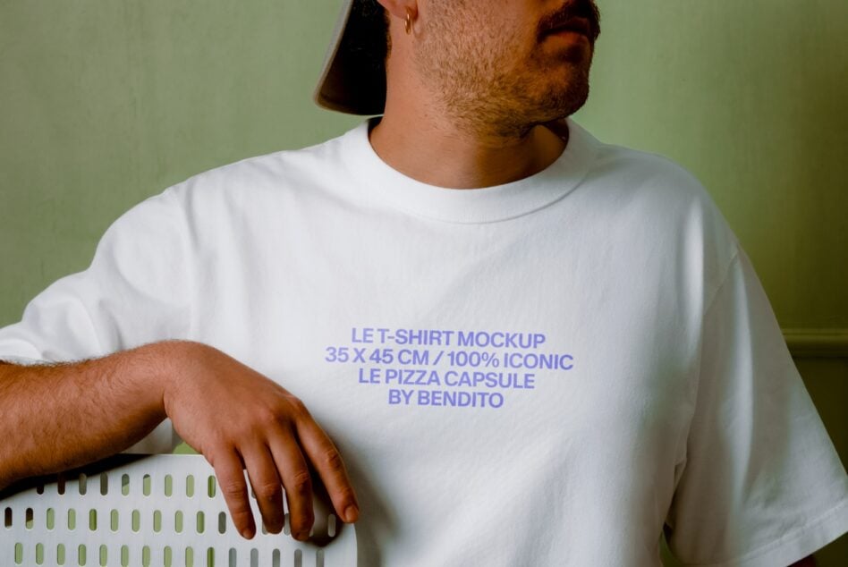 Guy in white tee against sage green background, text placement on chest, relaxed pose