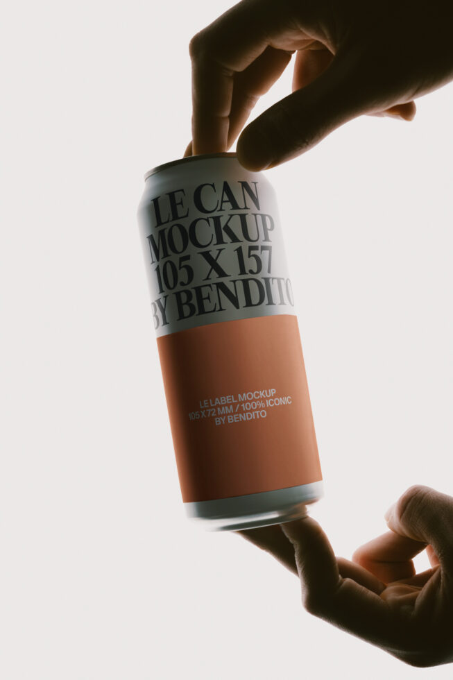 Hands holding aluminum can mockup with wrap label in terracotta, backlit studio shot