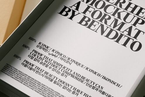 Book cover mockup shot overhead showing serif typography with multilingual text on cream paper in olive green frame