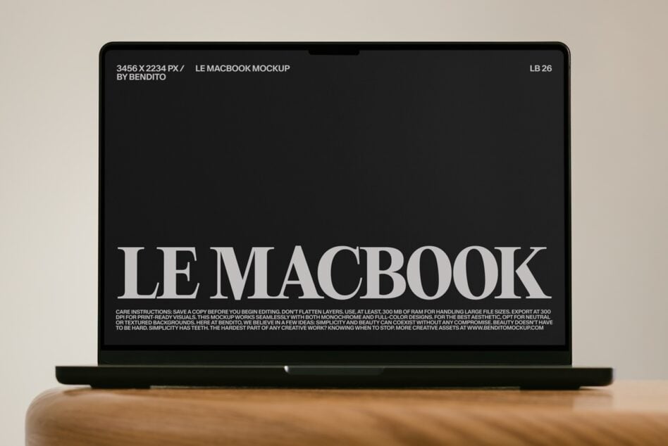 MacBook laptop mockup with minimalist serif typography on black screen, wooden surface backdrop