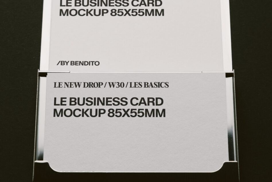 Stacked business cards in holder showing front, back, edge with black text on white stock
