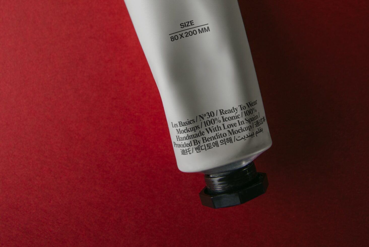 White cosmetic tube with multilingual label on red background, angled shot