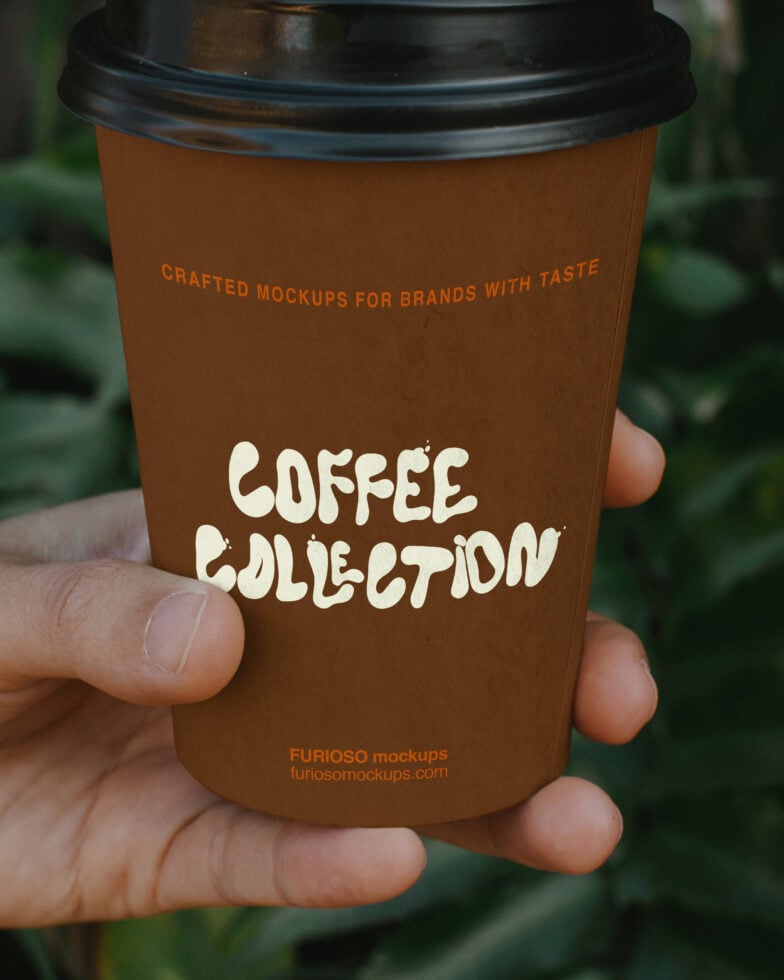 Coffee cup mockup with black lid, cream text, brown kraft paper held in hand outdoors