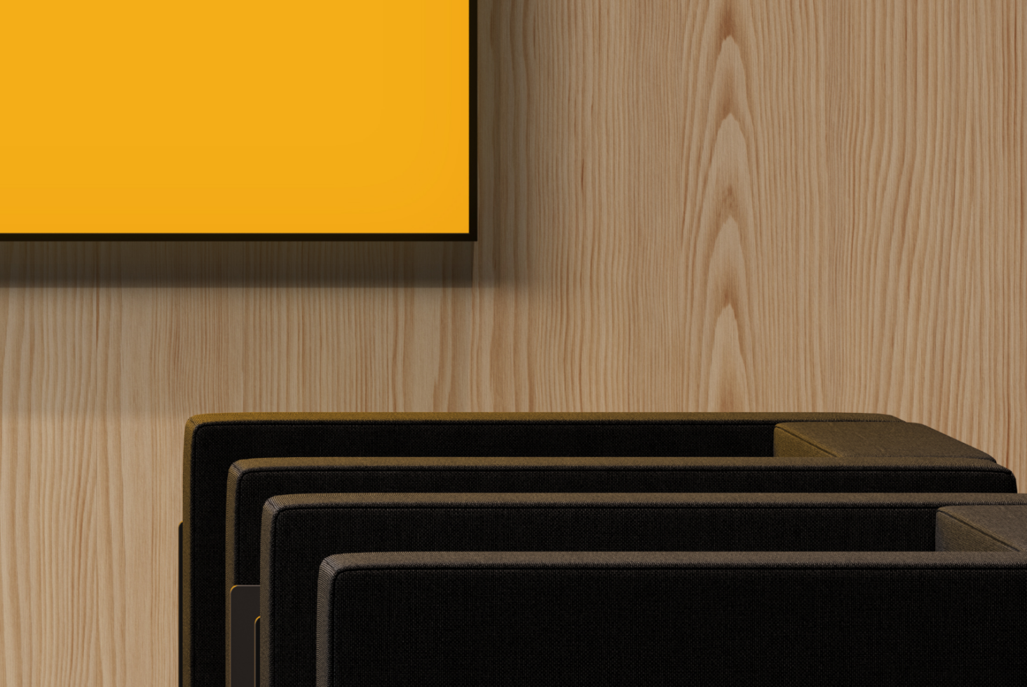 Stacked black frames with gold accents on light wood surface, yellow poster on wall above