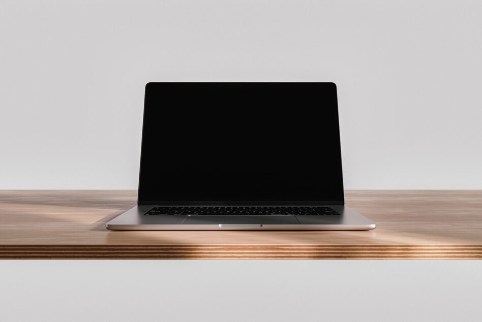 Laptop mockup on wooden desk with blank screen, neutral background
