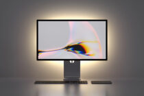 Desktop monitor mockup displaying vibrant chromatic aberration artwork with keyboard setup