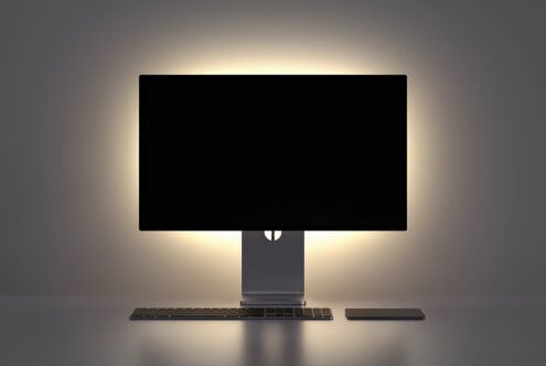 Modern desktop setup with monitor, keyboard, trackpad on soft gray backdrop