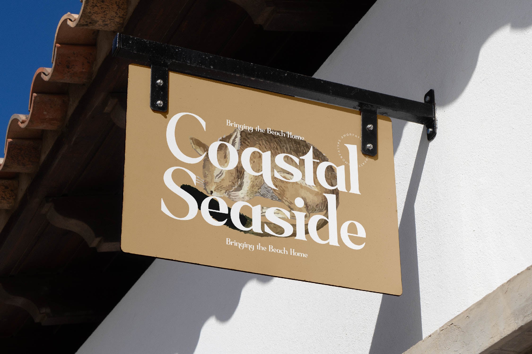 Hanging storefront sign with tan background, white serif typography reading "Coastal Seaside", seashell imagery, mounted on brick building