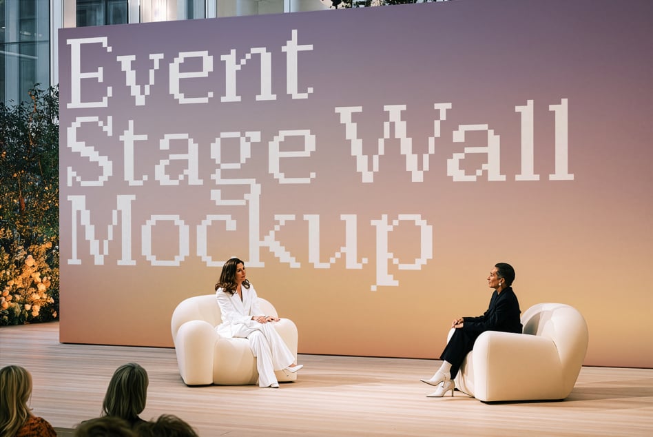 Event stage wall mockup with two speakers sitting in cream chairs, pixel font text on gradient backdrop