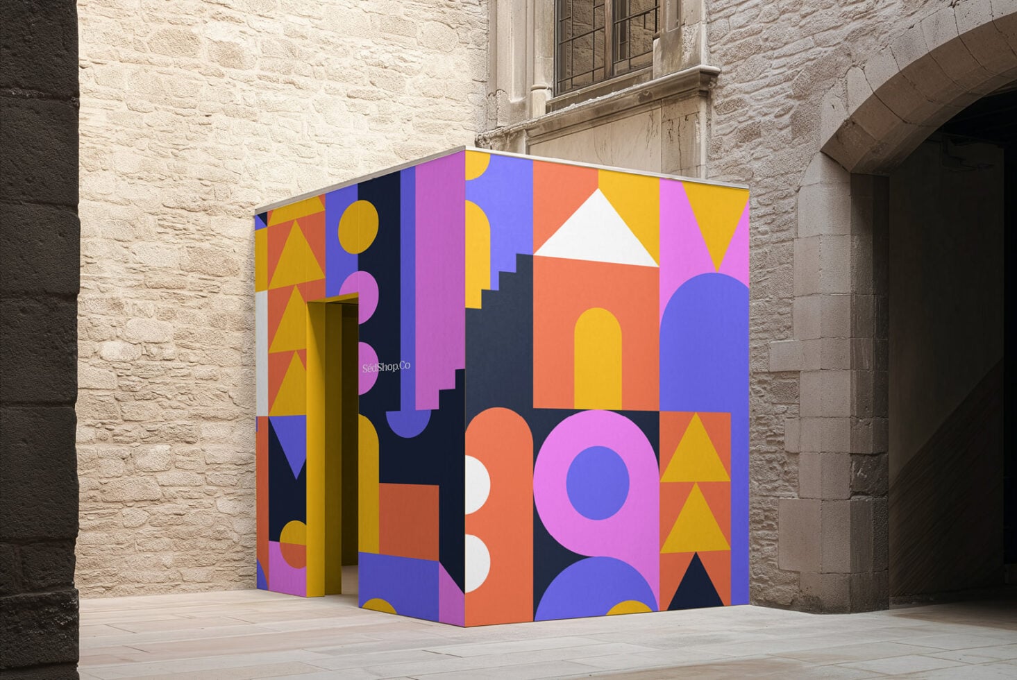 Colorful geometric storefront mockup with bold shapes, circles, triangles in vibrant pop art style against stone building