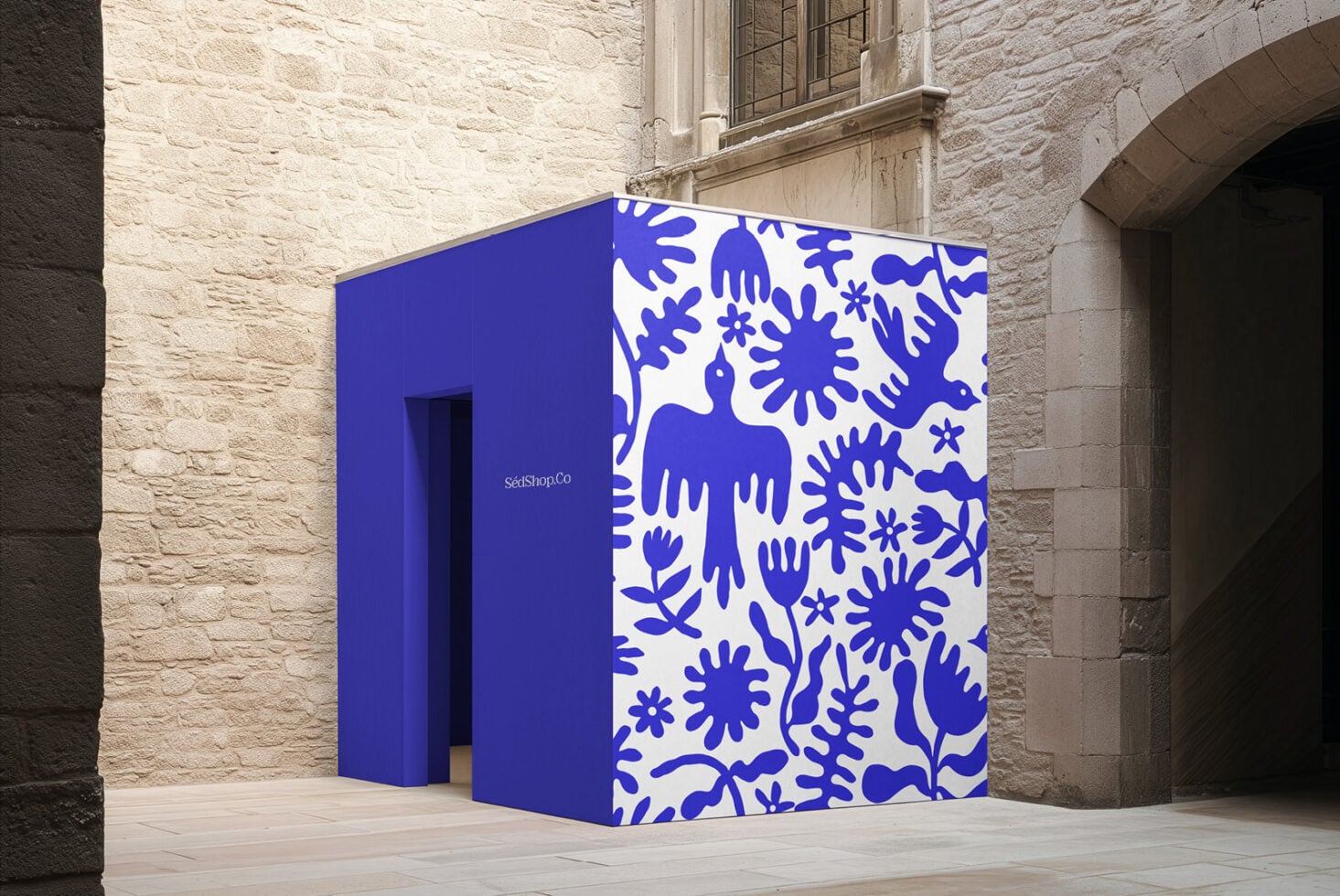 Bright blue pop-up shop with bold botanical pattern, stone courtyard setting, branding mockup