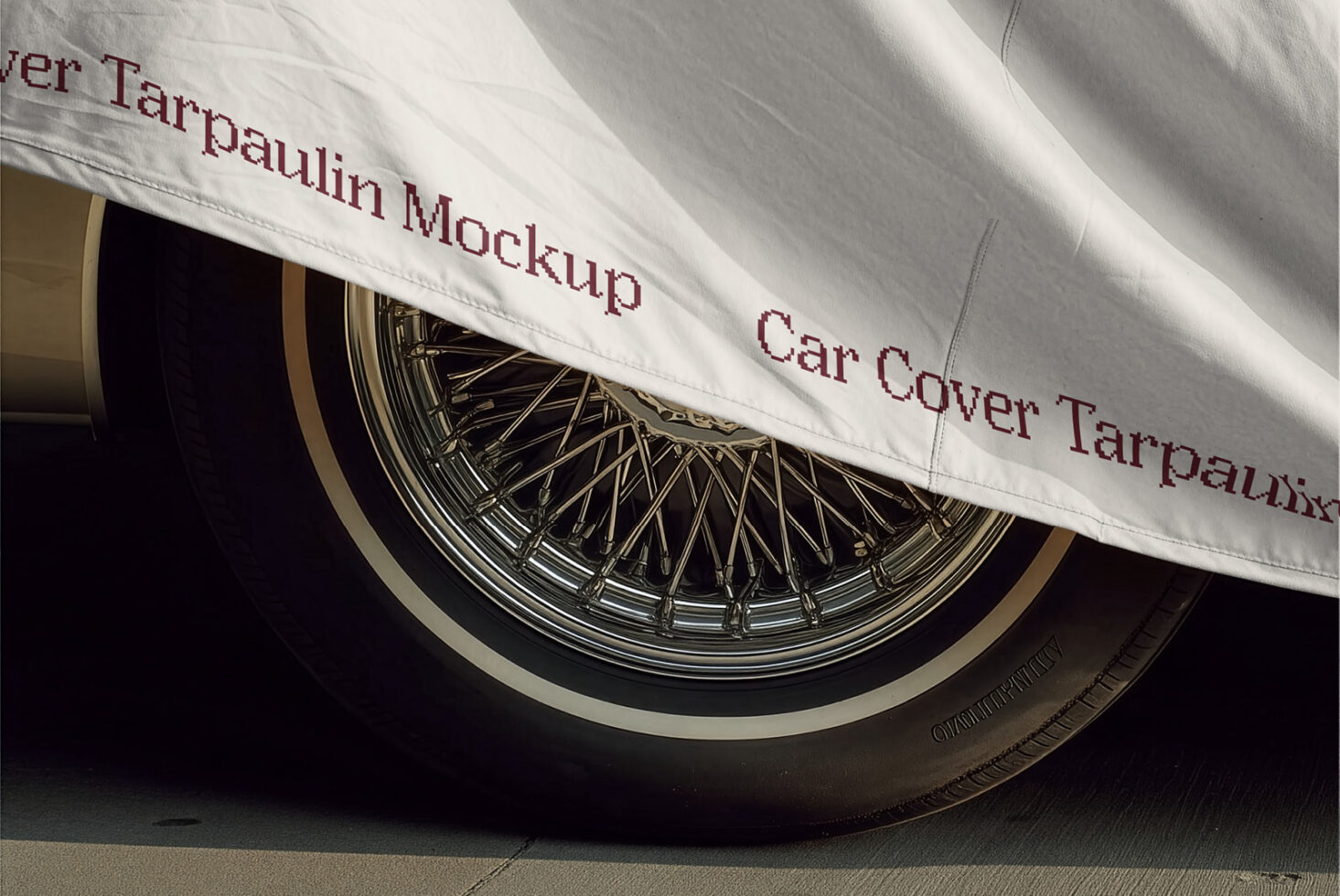 Car cover tarp draped over vintage wire wheel with burgundy text mockup