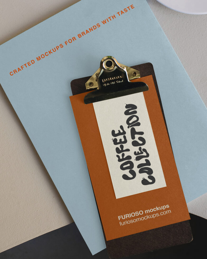 Clipboard mockup with orange backing, brass clip, cream label showing bold black lettering on light blue cover