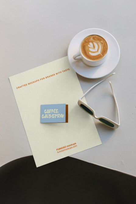 Overhead shot of cream paper with coffee branding mockup, latte with latte art, sunglasses on marble surface