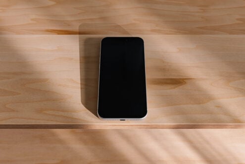 Smartphone mockup on light wood surface with natural shadow overlay