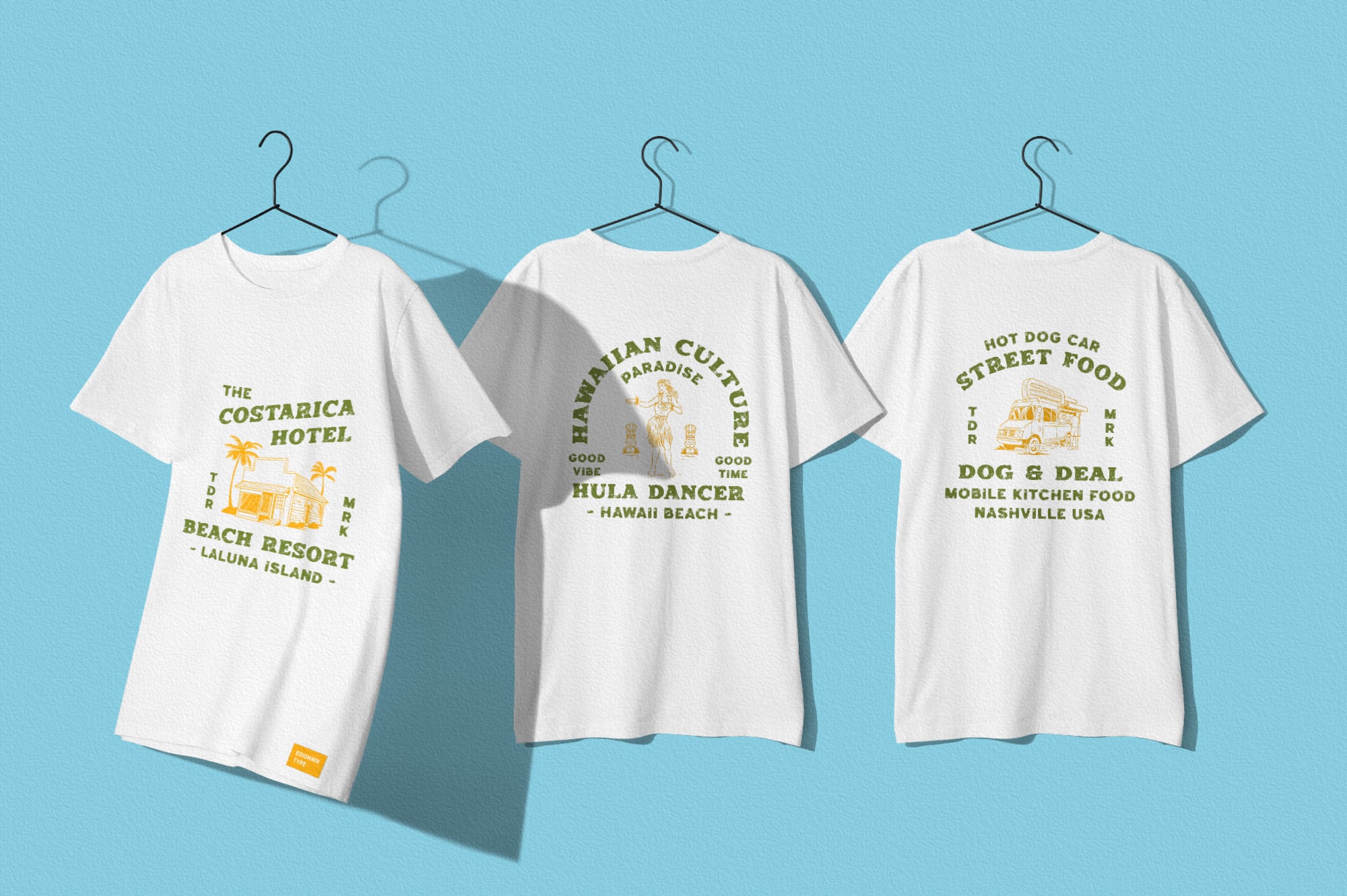 Three white tees on hangers with vintage travel graphic designs in olive green, gold, yellow