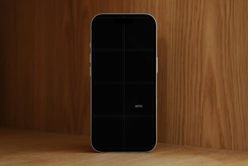 iPhone mockup with blank screen on warm wood backdrop, ready for your designs