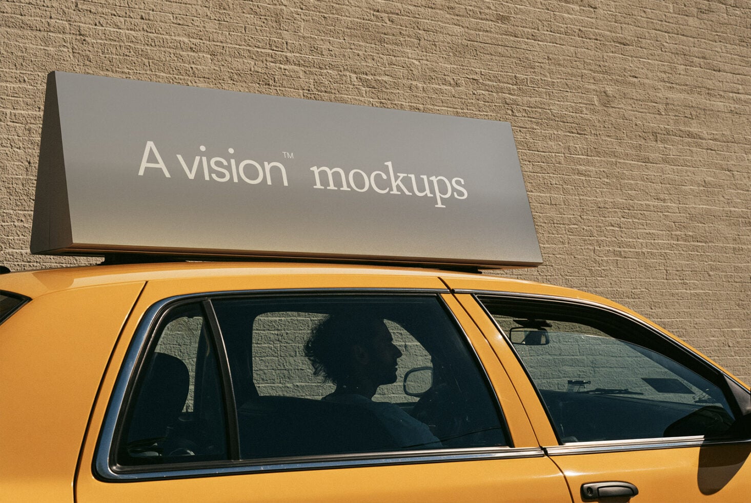 Taxi roof sign mockup with gray panel on yellow cab against brick wall