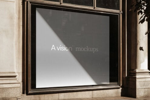Storefront window display with sunlight casting diagonal shadows across blank white space in black frame