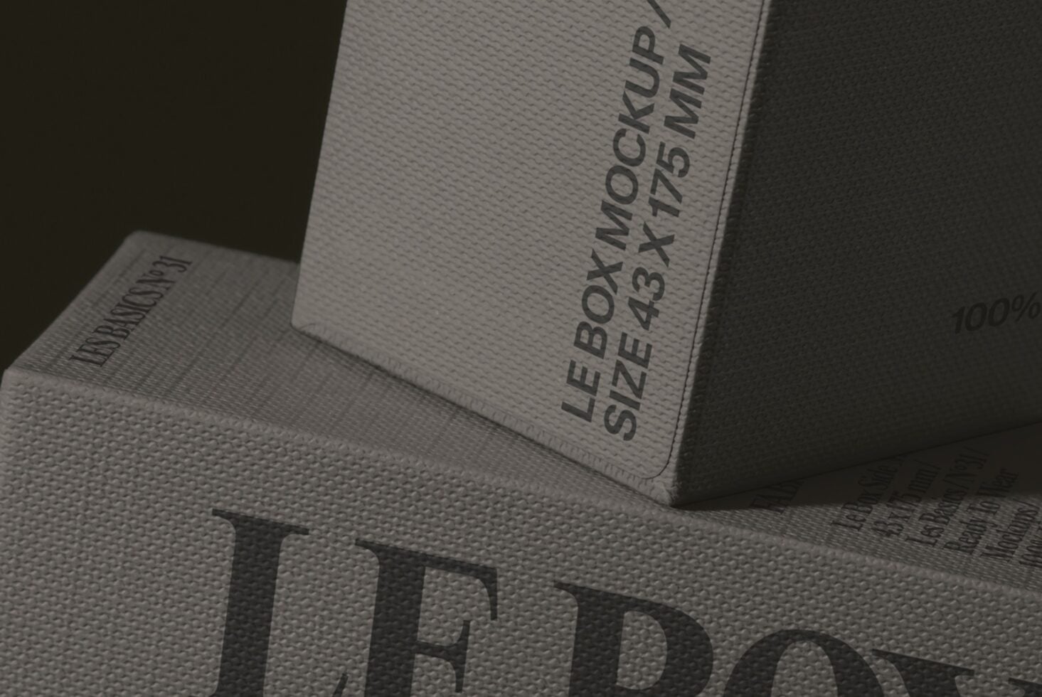Stacked product boxes with embossed text on textured paper stock, close-up angle