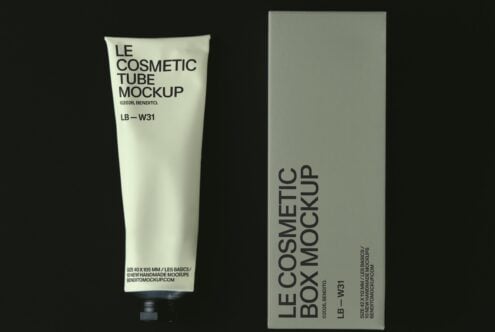 Cream tube with minimal branding next to its tall box on dark background