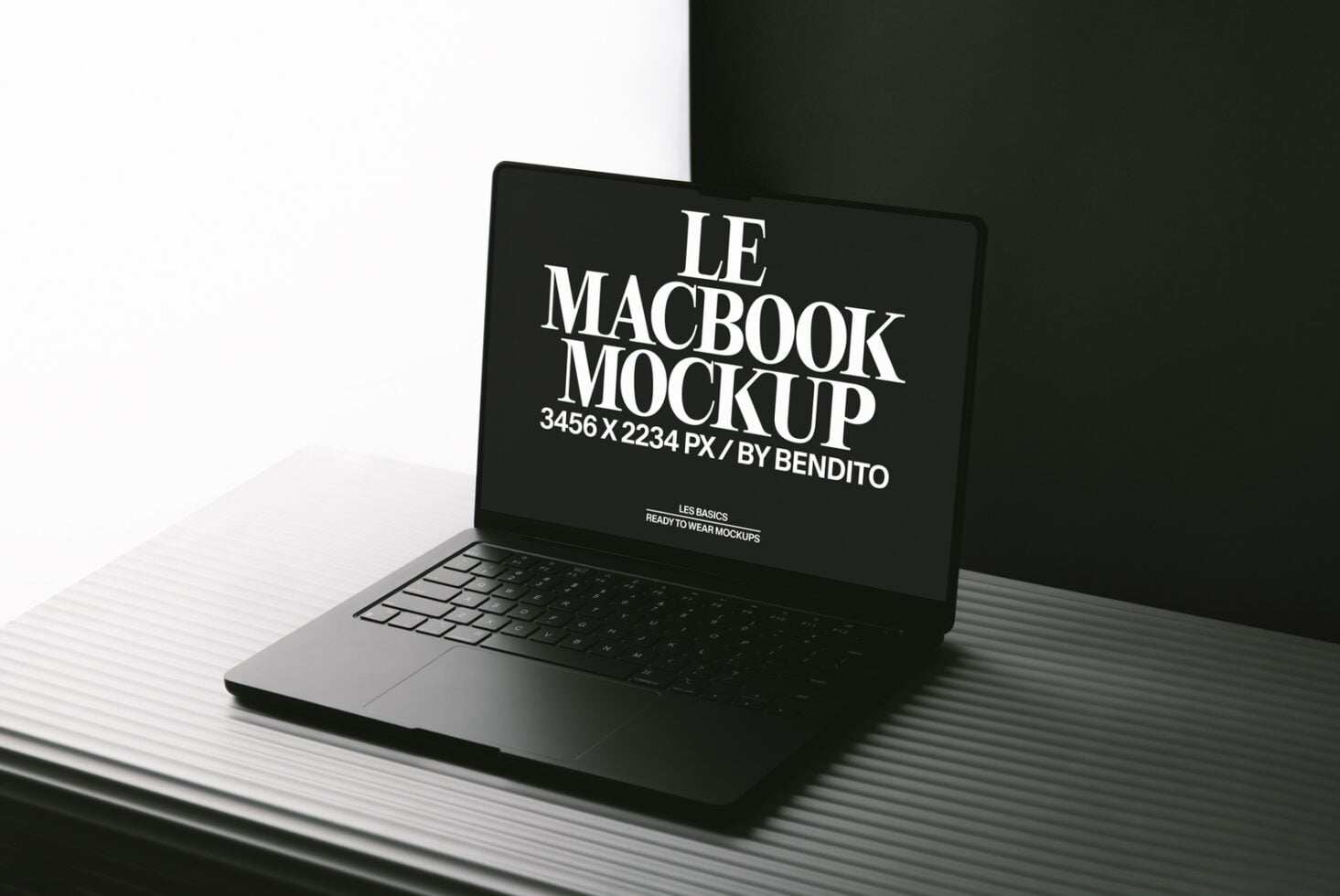 MacBook mockup on textured surface with minimalist black backdrop