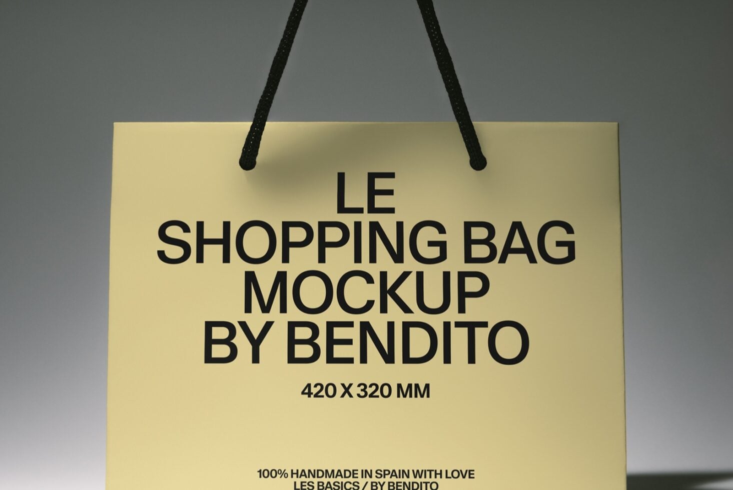 Cream shopping bag with black rope handles displaying bold text reading "Le Shopping Bag Mockup by Bendito"
