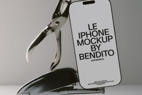 iPhone held by metal clamp showing screen with mockup text, neutral studio background