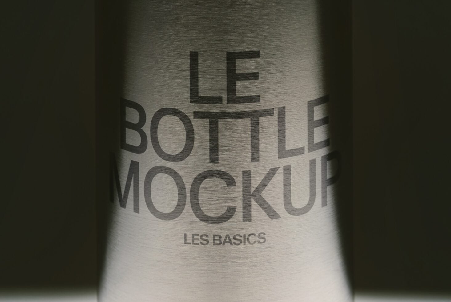 Metallic bottle with embossed text reading "Le Bottle Mockup" with "Les Basics" subtitle