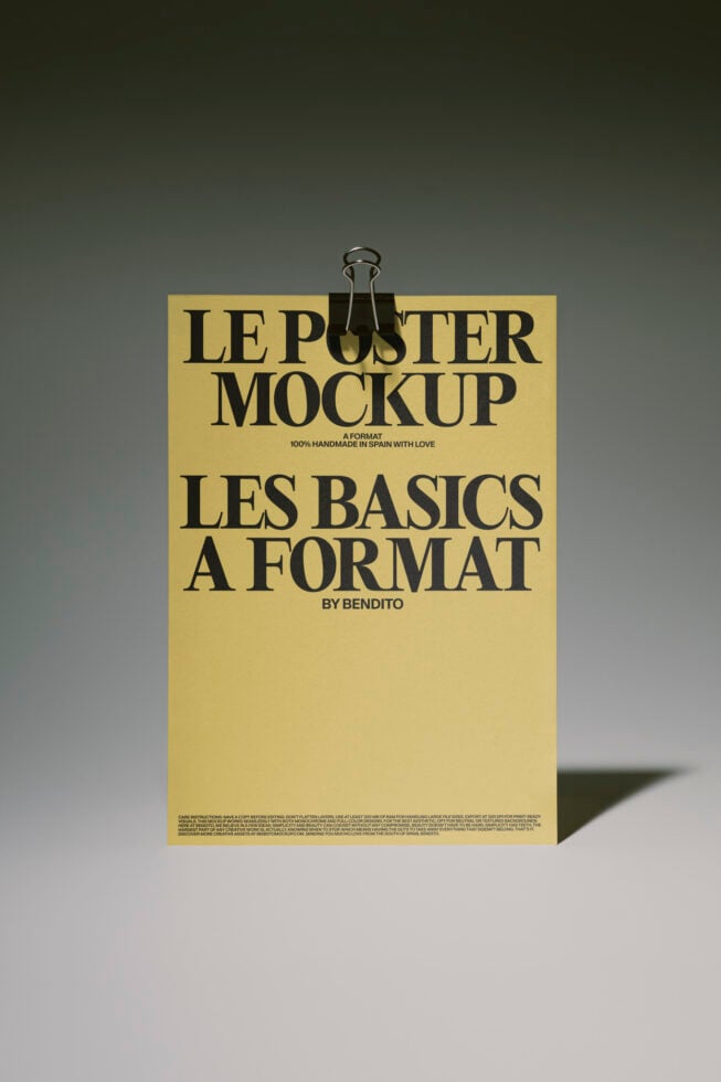 Pale yellow poster mockup with bold black typography, binder clip at top, casting sharp shadow on neutral background