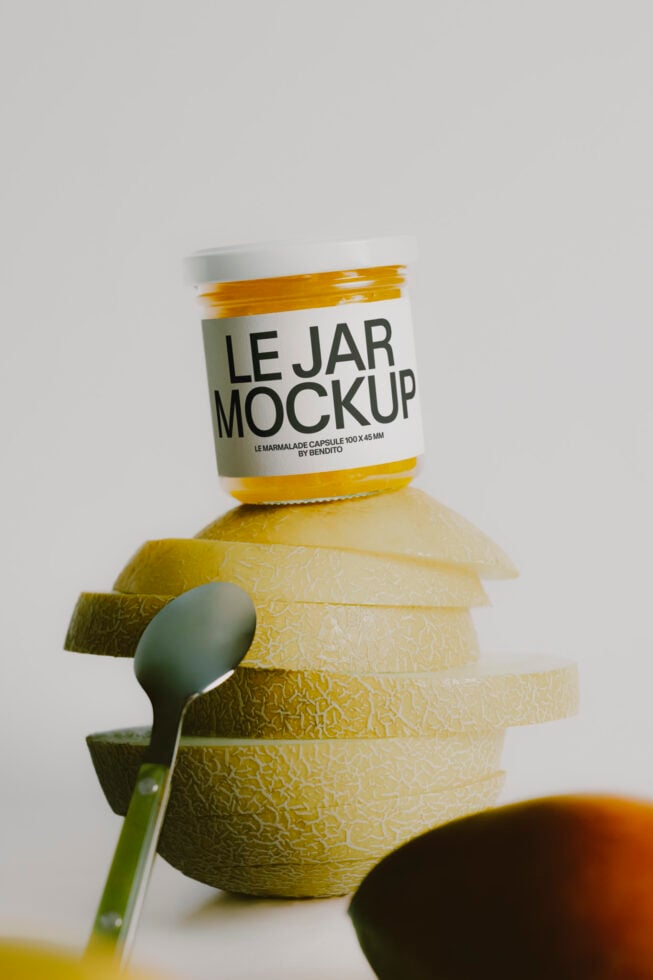 Jam jar mockup with white label stacked on sliced lemons, spoon on the side