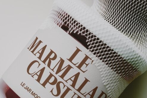 Closeup of textured mesh fabric wrapped around jar with brown serif typography on white label
