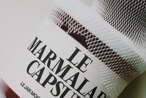 Closeup of textured jar label with serif typography reading "LE FLAT CAPASAT" on cream background