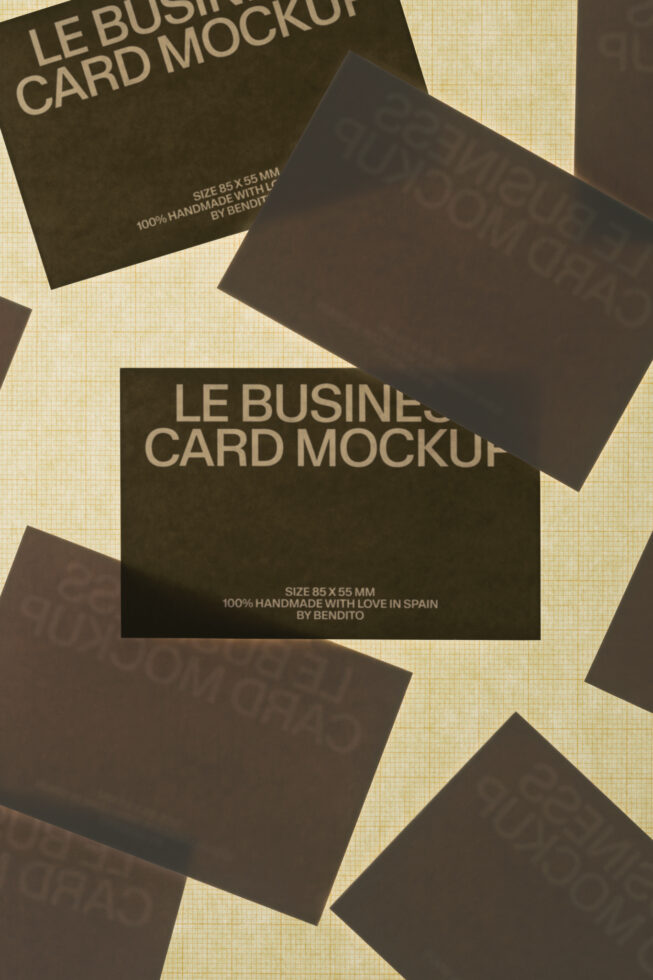 Dark business cards scattered on cream textured background with shadows