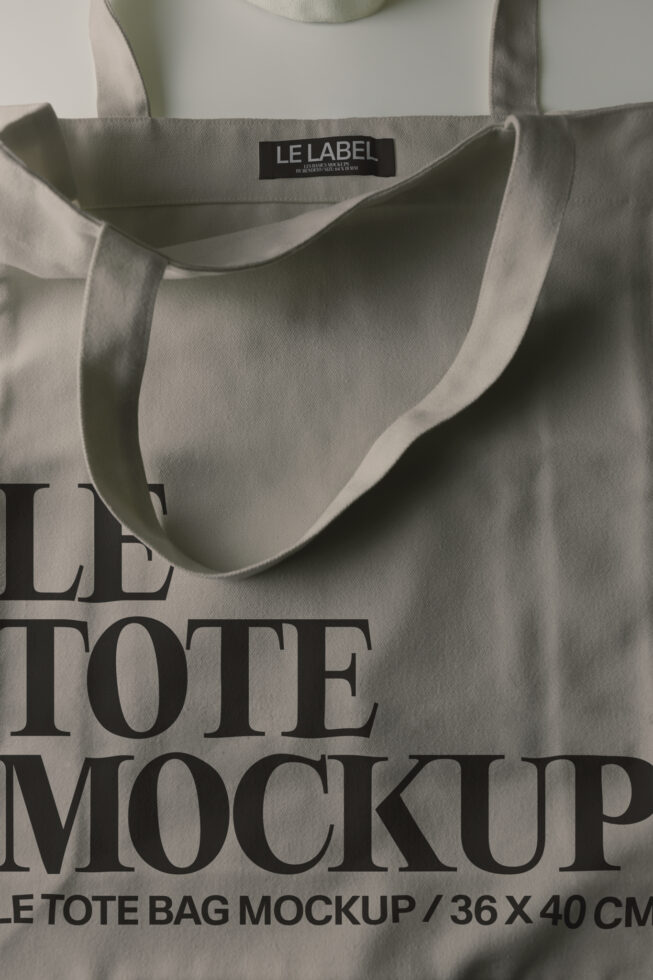 Cream canvas tote bag with black woven label showing "LE LABEL" branding text overlay