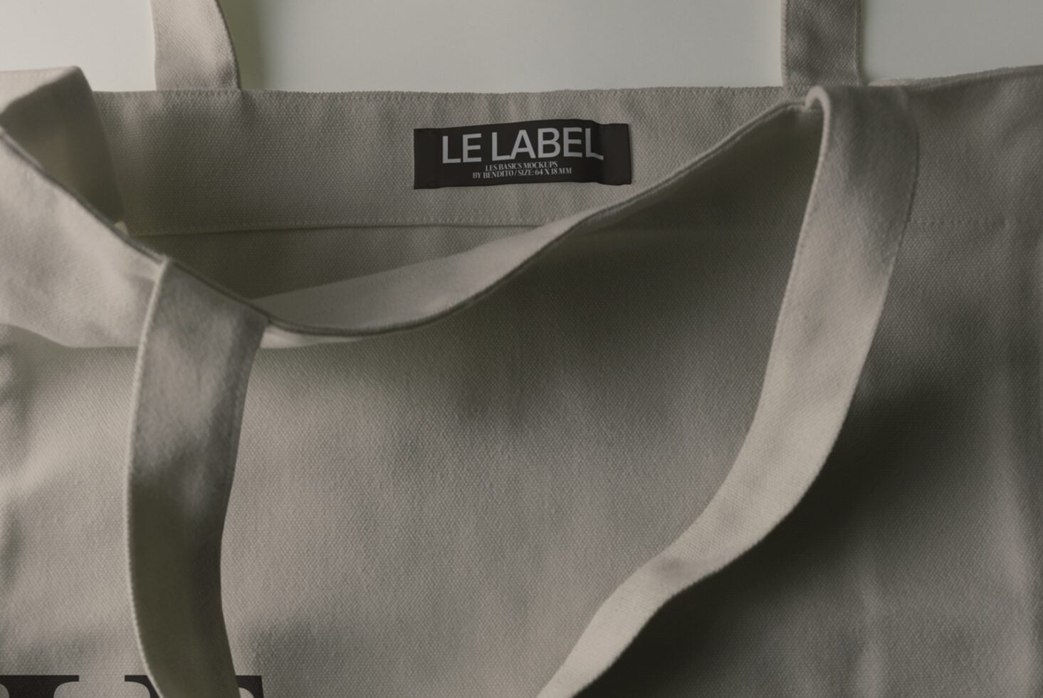 Beige canvas tote bag with black woven label showing "LE LABEL" branding