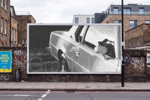 Vintage car billboard mockup on brick urban street with surrounding buildings