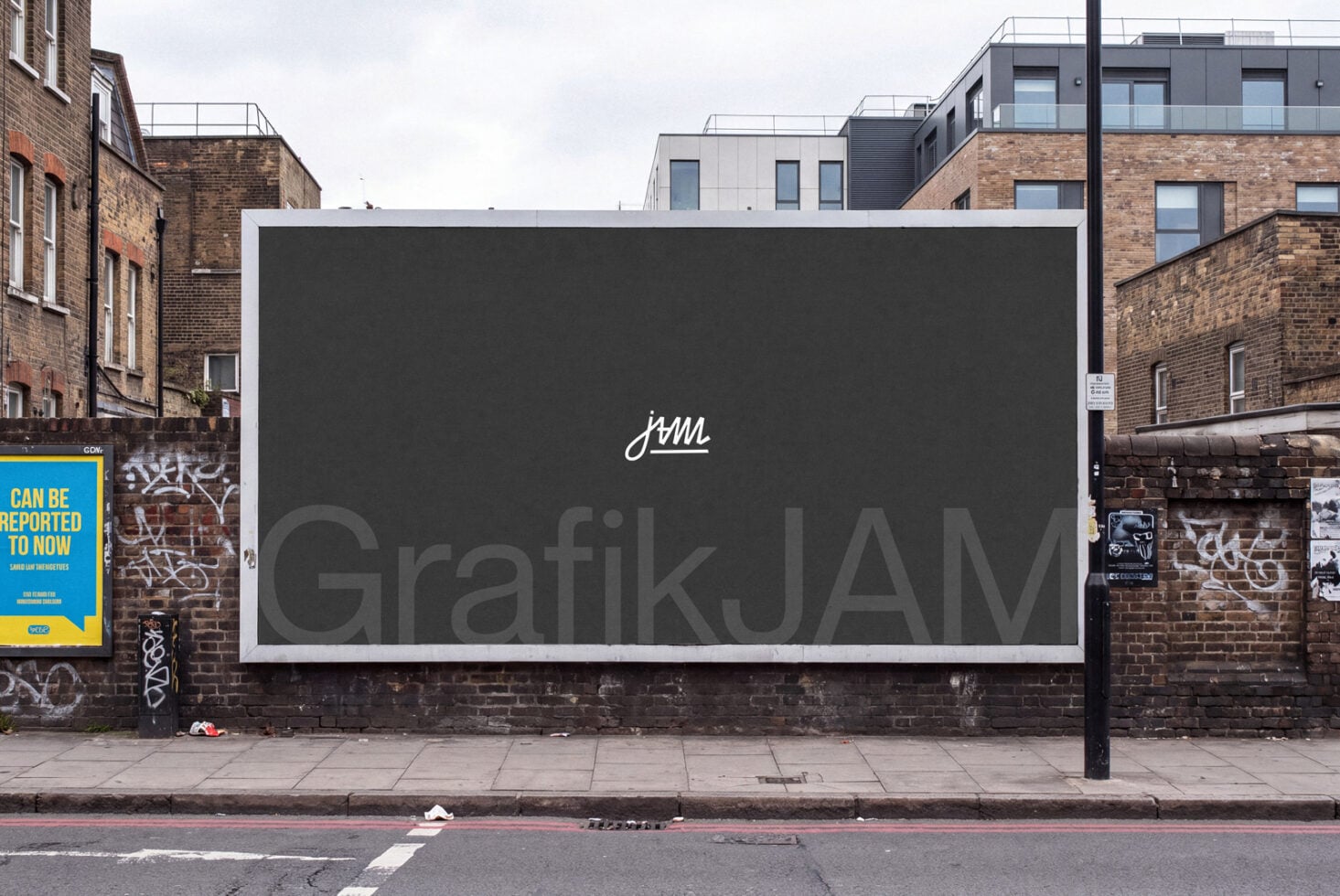 Large billboard mockup on brick urban street with white frame, dark display surface showing GrafikJAM logo