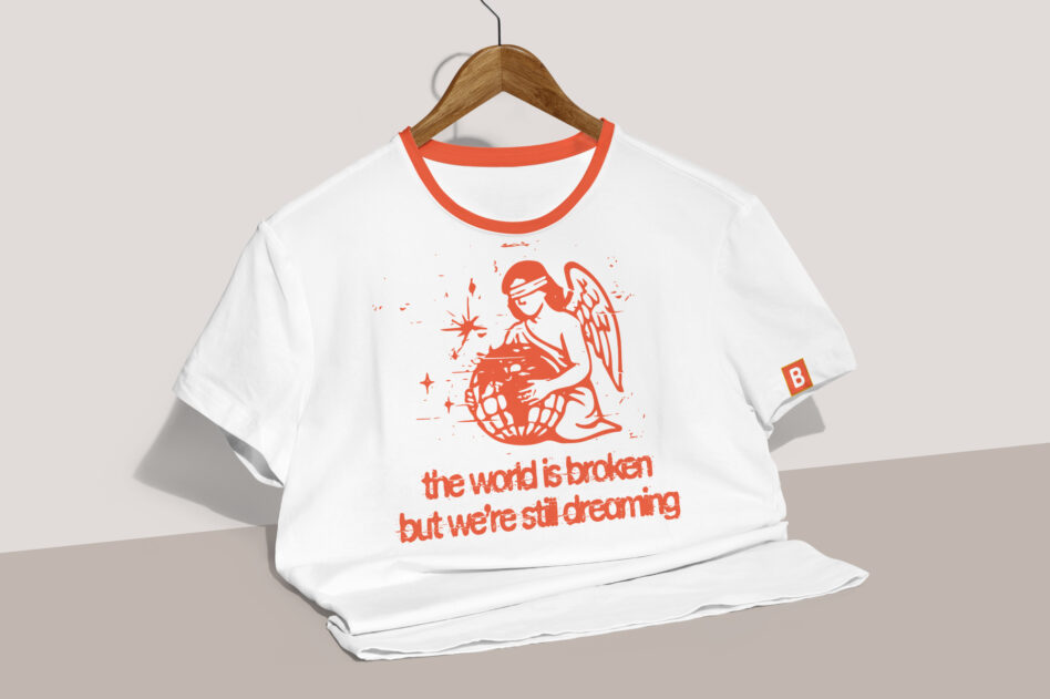 White tee with red ringer collar, angel graphic, optimistic quote printed on front