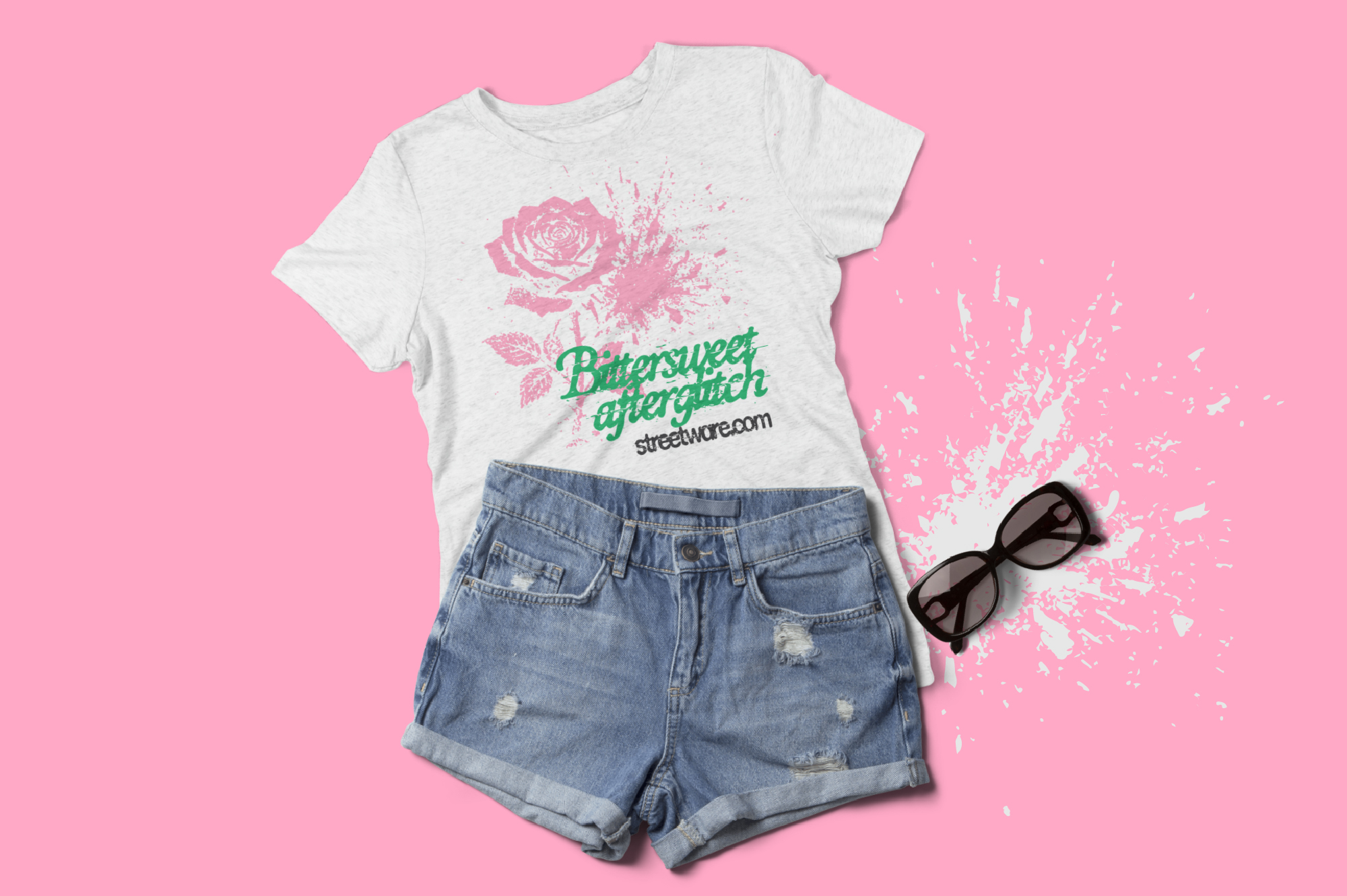 Cream tee with rose graphic styled with ripped denim shorts, sunglasses on pink background
