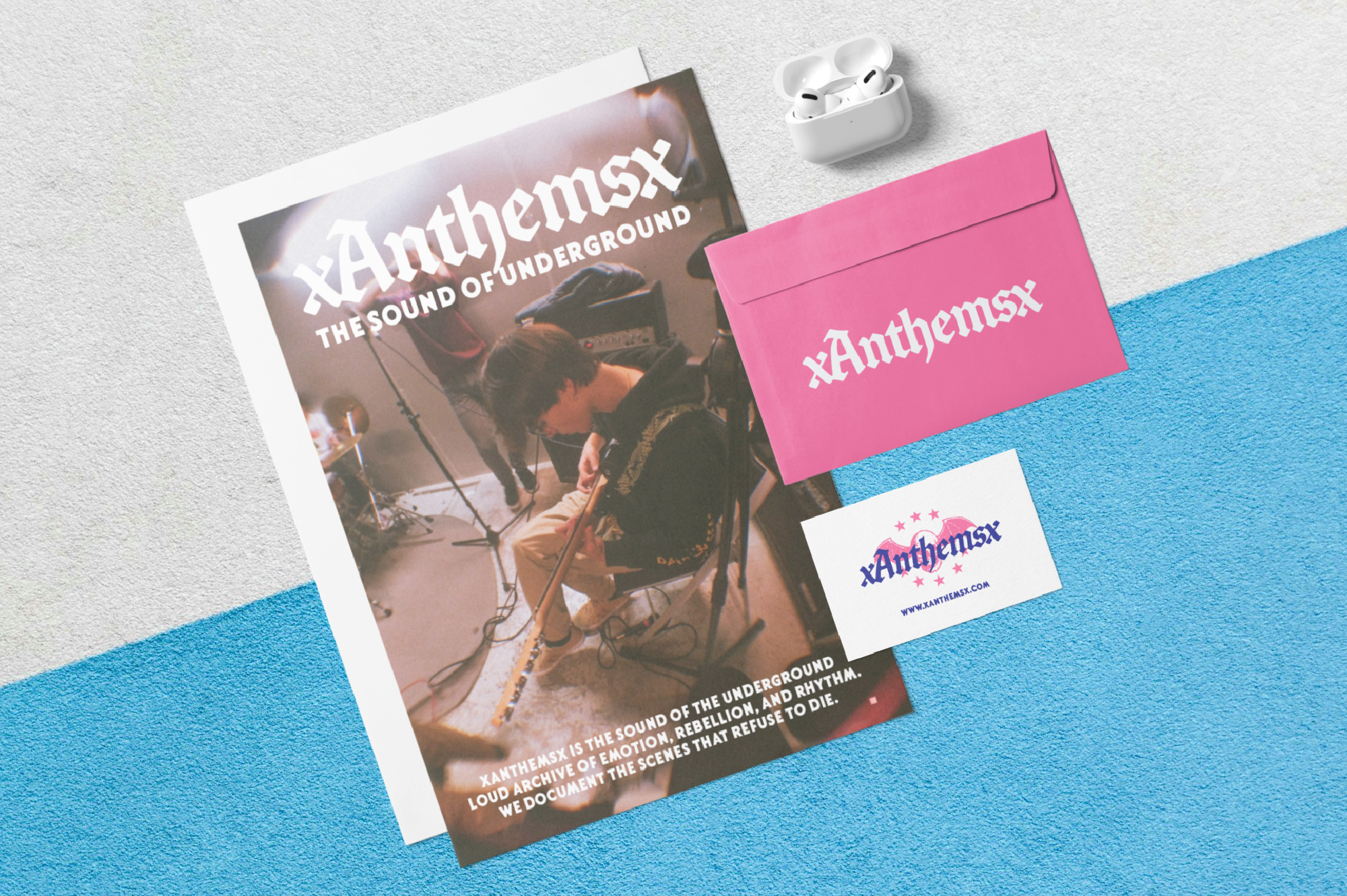 Branding mockup with poster, pink envelope, business card, plus white earbuds on blue background