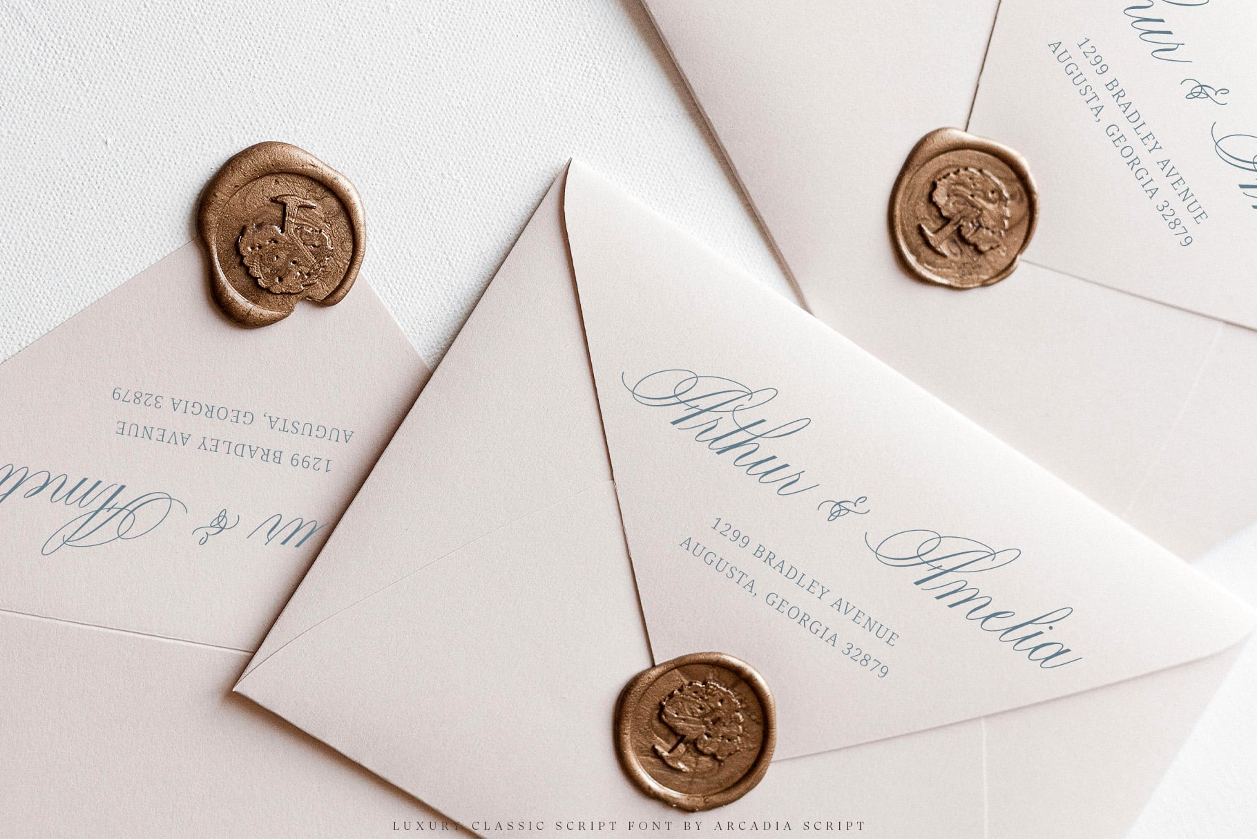 Cream envelopes with gold wax seals, calligraphy script addressing, formal wedding stationery mockup