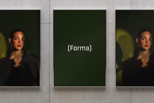 Three framed portraits on concrete wall, center frame shows dark green mockup with (Forma) text