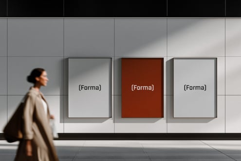 Woman walking past three framed posters on minimal gallery wall with natural light
