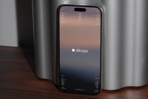 iPhone 14 Pro mockup displaying warm gradient screen with Akoya branding displayed centrally