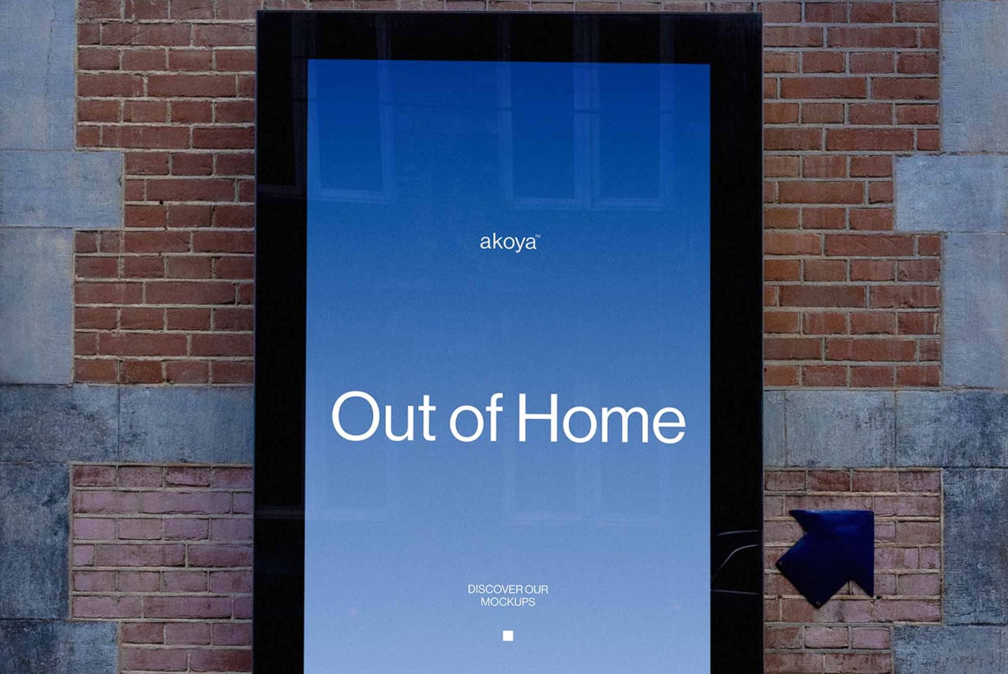 Digital billboard mockup on brick wall showing blue screen with "Out of Home" text