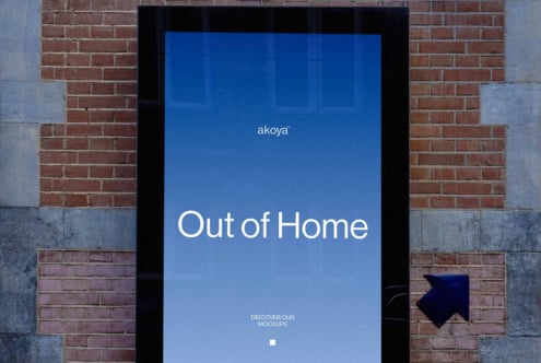 Digital billboard mockup on brick wall showing blue screen with "Out of Home" text