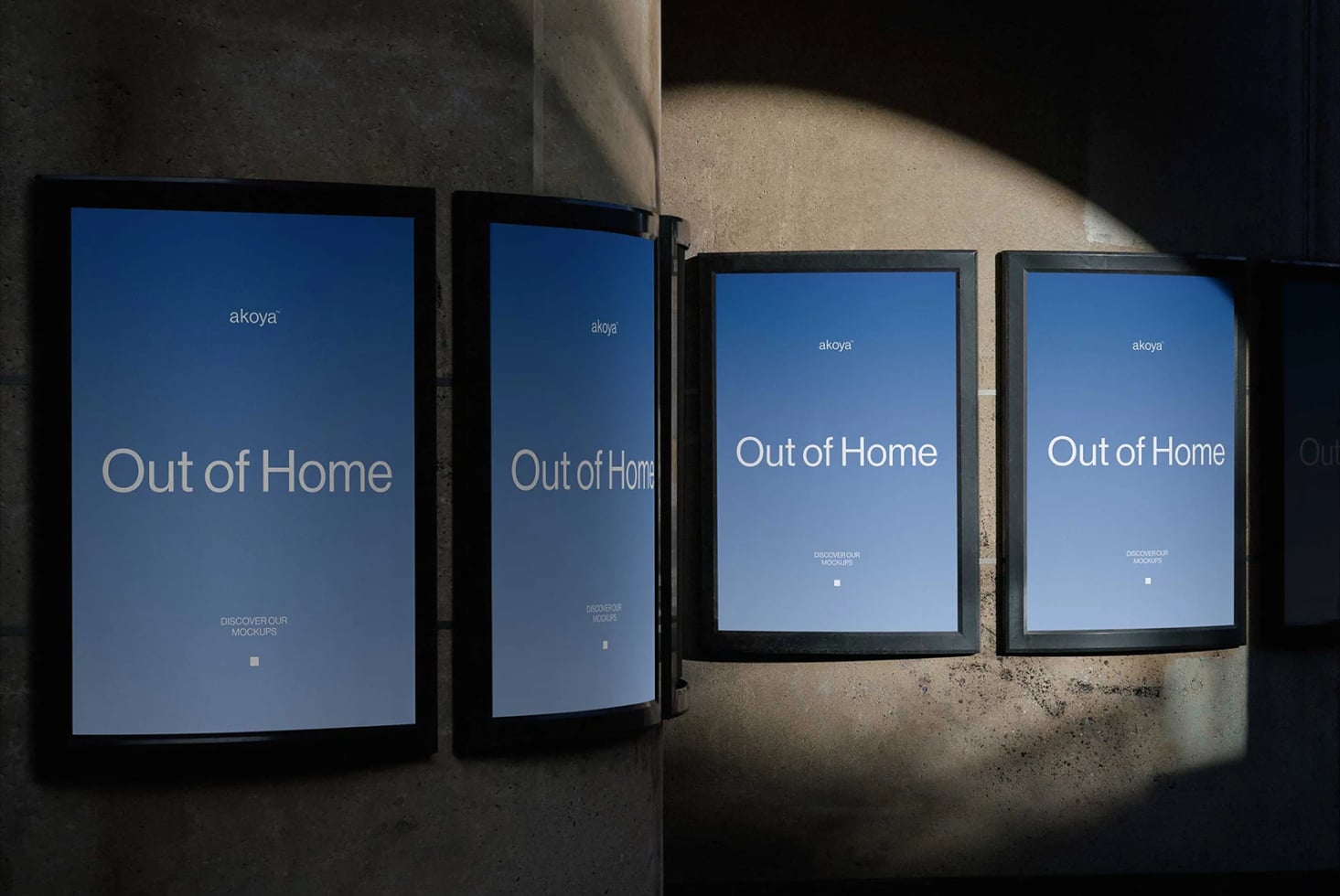 Four framed displays showing "Out of Home" campaign mockup on concrete wall with dramatic lighting