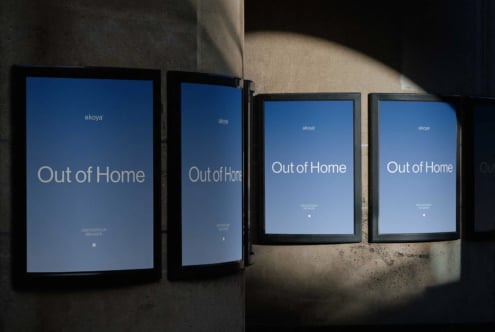 Four framed displays showing "Out of Home" campaign mockup on concrete wall with dramatic lighting