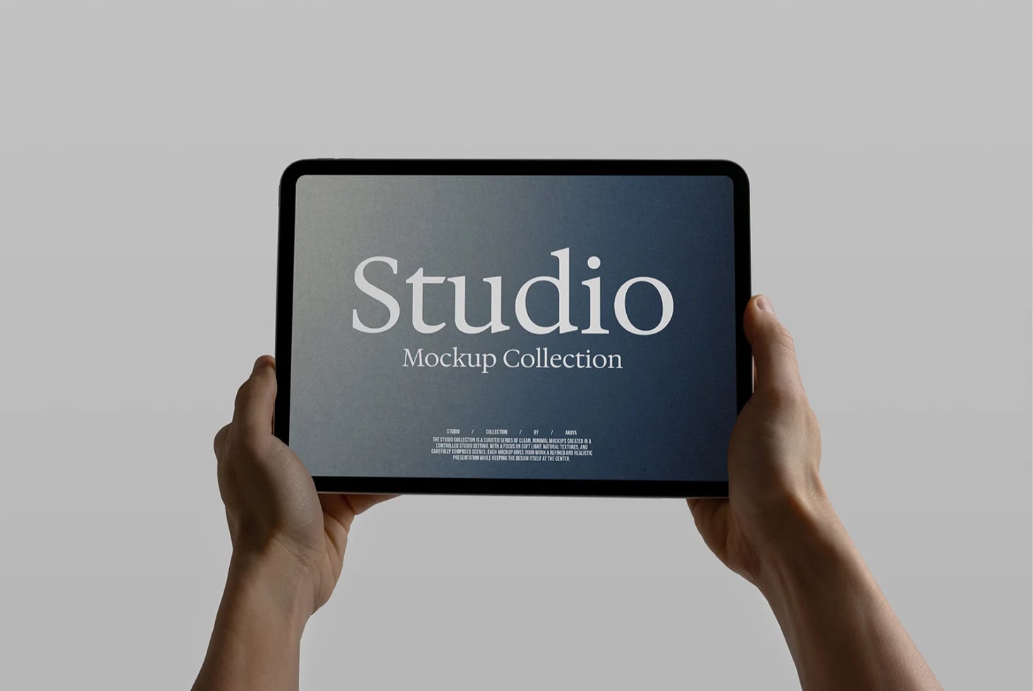 Hands holding tablet displaying Studio Mockup Collection title with elegant serif typography on dark gradient background